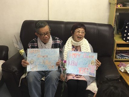 陈生陈太收到小朋友亲手编织的颈巾和图画，笑逐颜开。