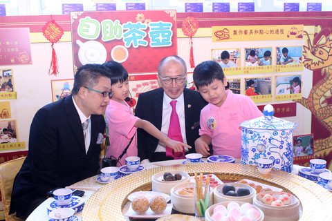 幼儿为嘉宾介绍作品「自助茶壶」
小朋友发现长者斟茶时或因茶壶重量而有困难，遂发明自助茶壶，运用感应器自动斟茶；并配合运输带将茶杯送到每个座位。