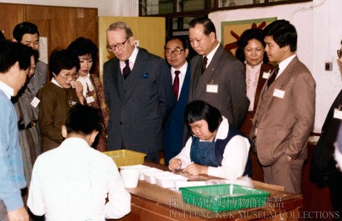 Acting Governor Sir Philip Haddon-Cave (second from right in front) visiting Po Leung Kuk Centenary School, accompanied by Po Leung Kuk Chairman (1983-84) Mr Ng Shue Chiu (third from right in front).