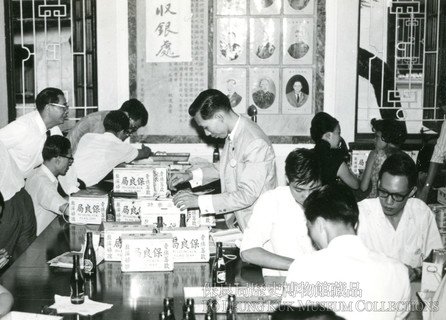 1964年卖旗日於关帝厅点算筹款箱的状况。早年点算工作除由职员参与外，亦会有总理旗下公司职员义务协助。