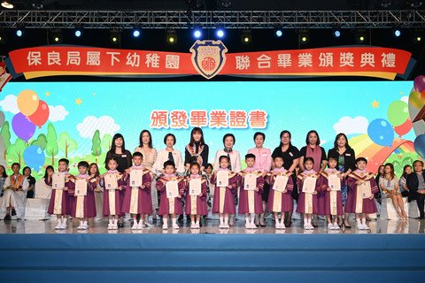 教育局蔡若蓮局長(後排右五)親授畢業證書予畢業生代表，祝賀各幼稚園畢業生愉快成長。