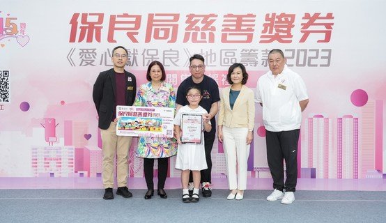 慈善獎券版面主題圖案由保良局錦泰小學楊心妤同學設計，開售禮上接受主禮人頒發的獎狀。