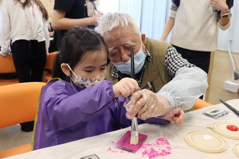 長者與幼兒一同合作以卡式錄音帶舊物創作藝術品。