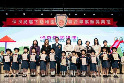 教育局杜永恒副秘書長(後排左三)親授畢業證書予畢業生代表，祝賀各幼稚園畢業生愉快成長。