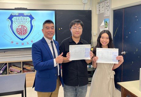 相片二︰
保良局董玉娣中學的李子豪同學（中）考獲5科「5**」，成為榜眼；同校的尹柏晴同學（右）曾於中四患病入院，仍最終考獲佳績，兩位同學與劉子聰校長（左）合照。

