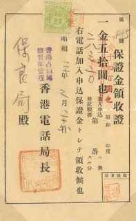 電話局保證金領收證(1945年2月20日)
香港淪陷期間，電話線及其他公用設施需向軍政府繳交保證金，單據上亦可見拾錢印花稅郵票。