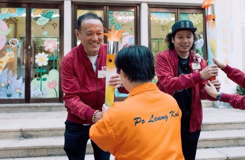 翁金骅先生（左）、阿感（右）分别从保良局服务使用者及管理层手上接过火炬，寓意将共融讯息传遍保良局属下社服单位。
