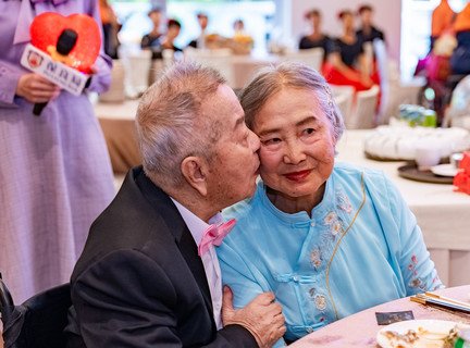 長者「新人」穿上婚紗禮服，親吻摰愛伴侶。